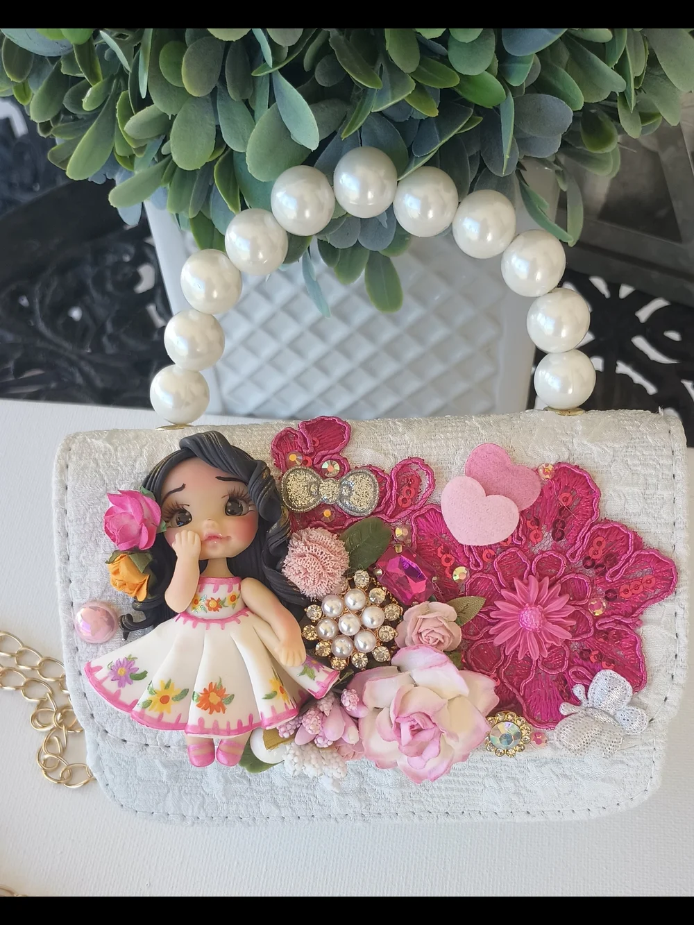 Handcrafted Pearl Handle Mini Bag With Clay Doll& Floral Applique.